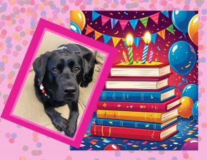 A black Labrador Retriever siting next to a stack of books with four birthday candles and balloons.