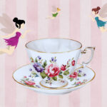 A flowered tea cup with three colorful fairies